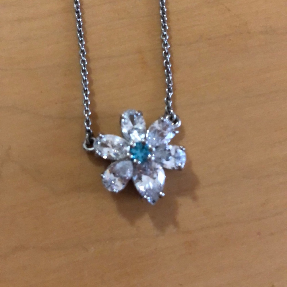 Flower necklace, white petals and blue center.